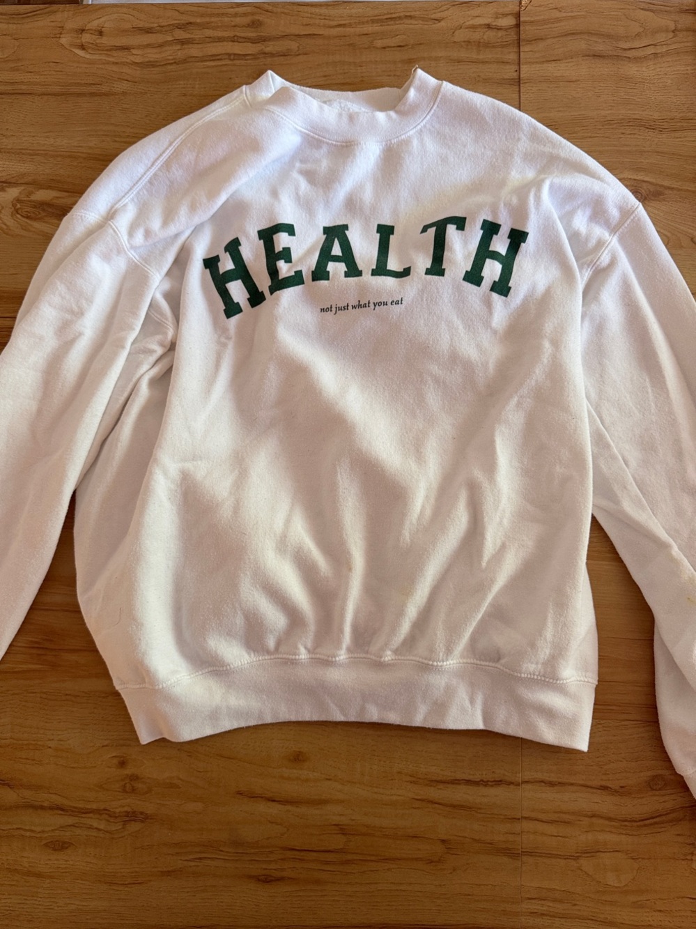 White Sweatshirt with Green "HEALTH" Graphic